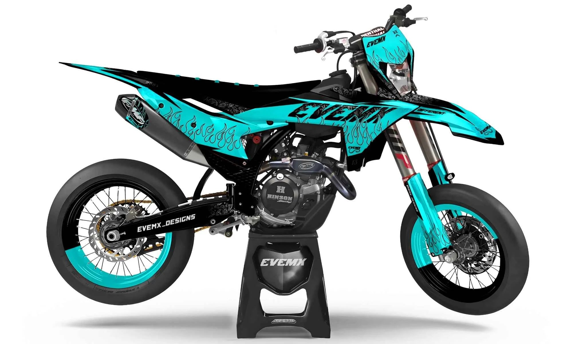 Turquoise and black motorcycle on a stand with 'EVEmx designs' branding.