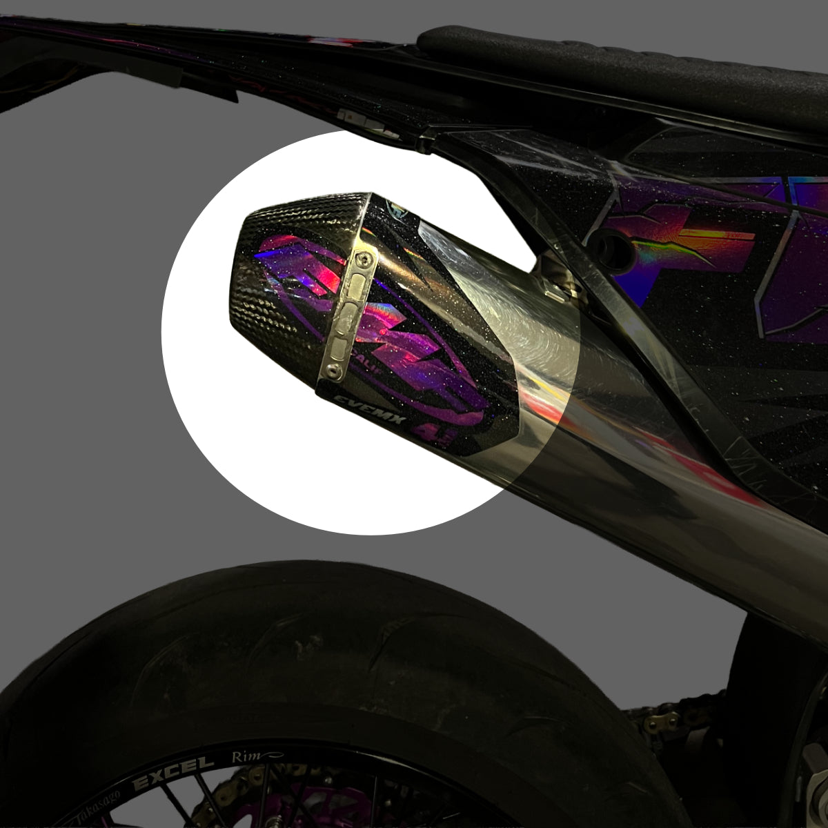 EveMx Designs Close-up of a motorcycle mirror with a colorful reflective surface on a gray background